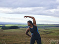 Female runner stretching in rural landscape