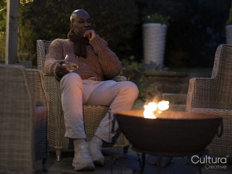 Man sitting by fire pit on patio