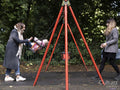 Female couple swinging baby in park