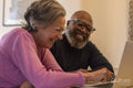 Senior couple using laptop at home