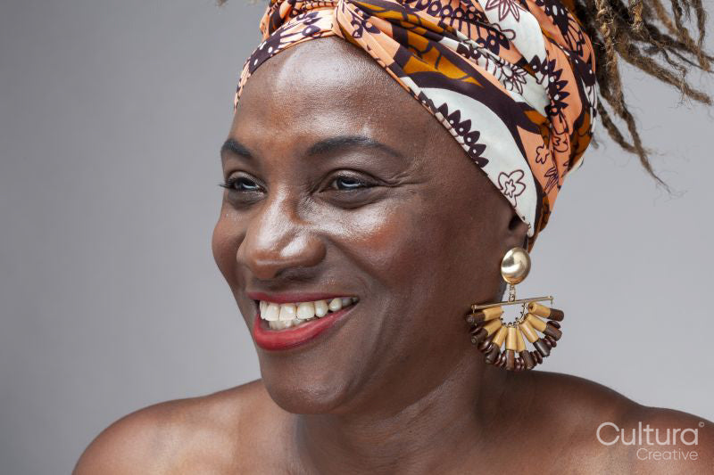 Studio shot of smiling mature woman in headscarf