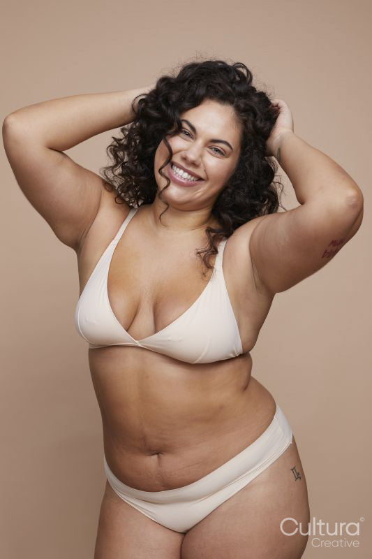 Studio portrait of smiling young woman wearing lingerie