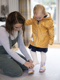Mother helping daughter to put on shoes