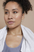Studio portrait of athletic woman with towel around neck