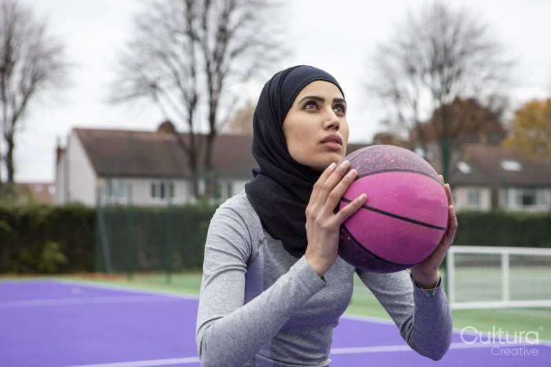 Woman in hijab playing basketball