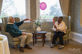 Smiling senior man and woman playing with balloon in nursing home