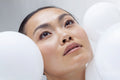 Close-up of woman with white balloons