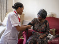 Nurse taking care of elderly woman, measuring blood pressure