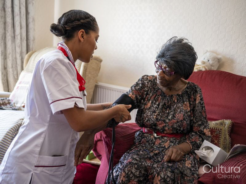 Nurse taking care of elderly woman, measuring blood pressure