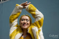 Young woman with yellow hair holding arms up