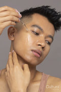 Close-up of person applying serum on face
