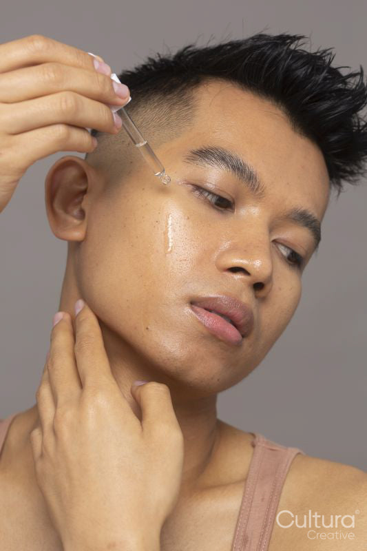 Close-up of person applying serum on face