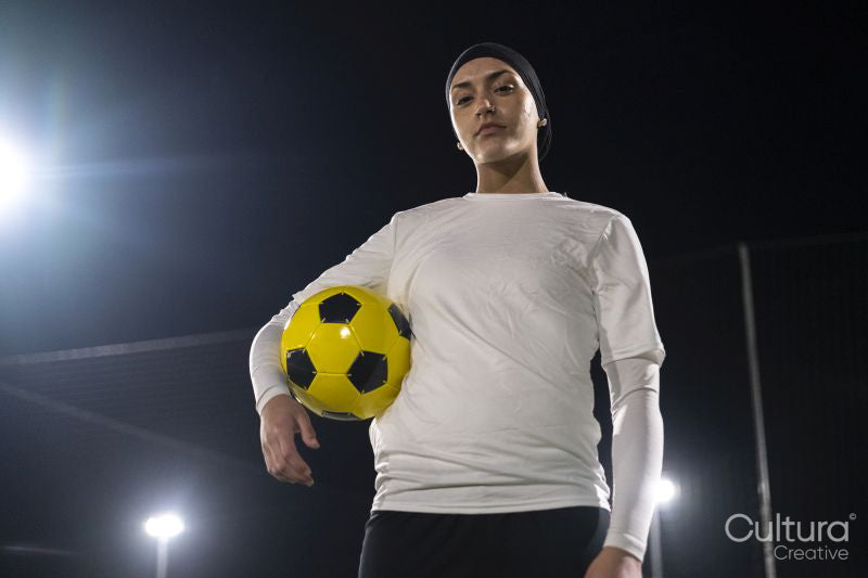 Portrait of female soccer player holding ball