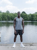 Portrait of muscular man in sports clothing standing by lake