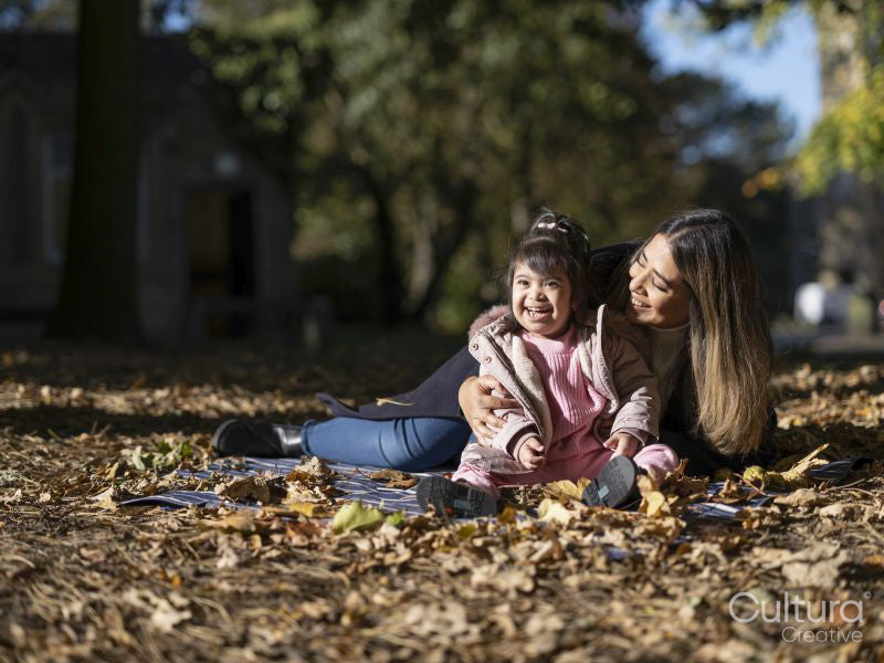 Mother and daughter with Down syndrome playing in park