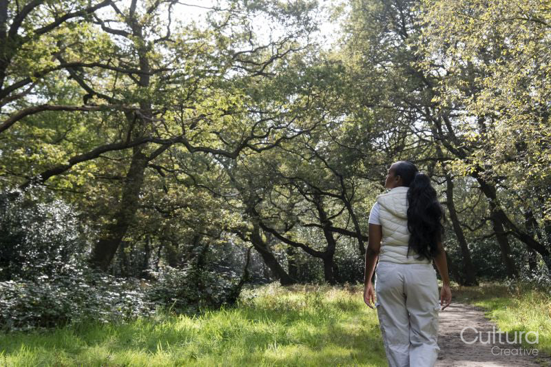 Rear view of woman walking in park on sunny day