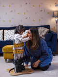 Mother putting daughter in standing frame
