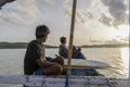 Indonesia, Lombok, Surfers looking at sea view from boat at sunset