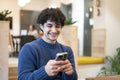 Smiling businessman using smart phone in office