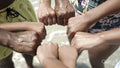 Close-up of family putting fists together on beach