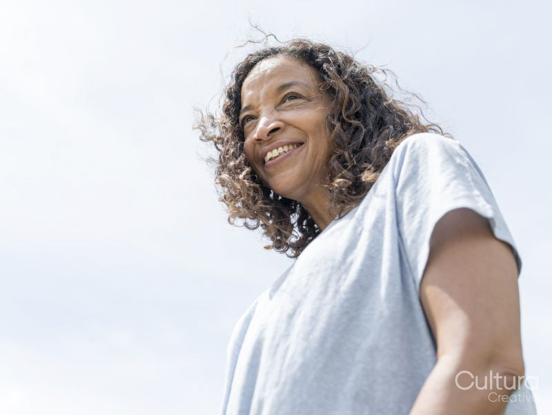 Portrait of smiling woman against sky