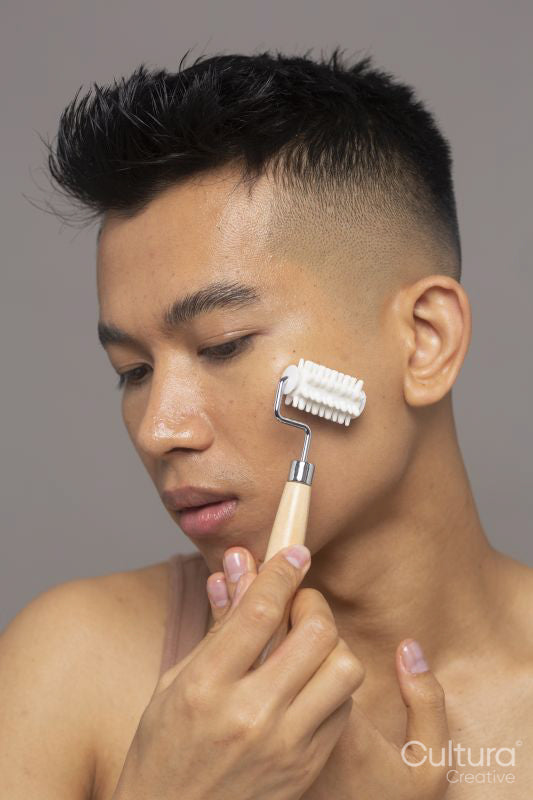 Studio shot of person using face roller