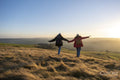 Female hikers holding hands in rural landscape