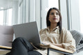 Businesswoman with laptop sitting in office lobby