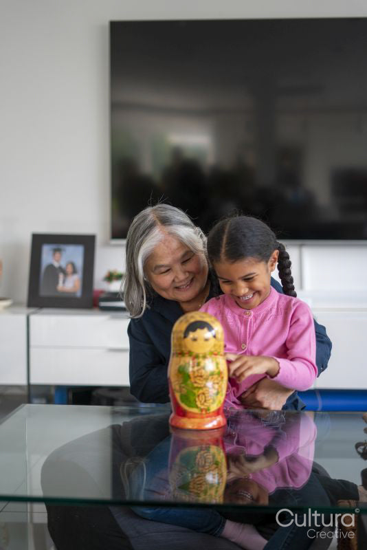 Senior woman with granddaughter playing at table in living room