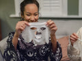 Friends applying face masks in living room