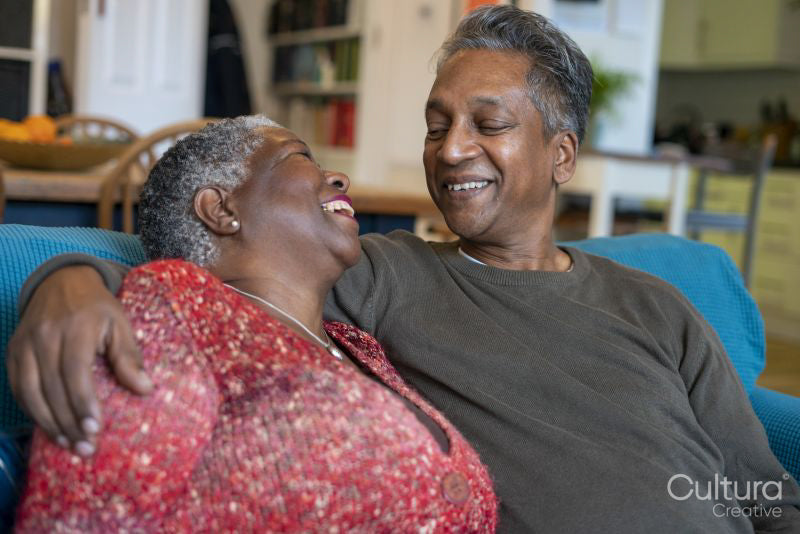 Senior couple sitting on sofa and embracing