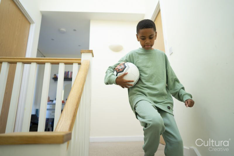 Boy walking down stairs with soccer ball