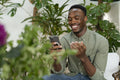 Young man with smartphone sitting in office lounge