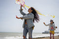 Mother and daughter flying kite on beach