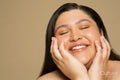 Studio portrait of smiling young woman with eyes closed