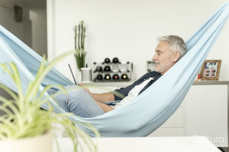 Smiling mature man using digital tablet in hammock