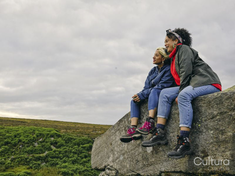 Female hikers sitting on rocks and looking at landscape