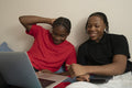 Teenage friends watching video on laptop at home
