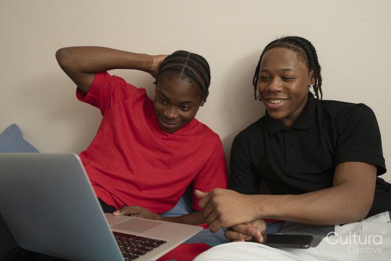 Teenage friends watching video on laptop at home
