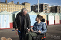 Father and disabled son strolling on promenade