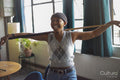 Laughing young woman holding pool cue at home