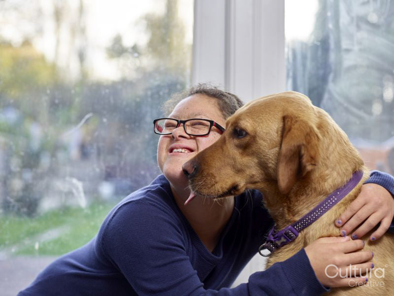 Girl with Down syndrome hugging dog