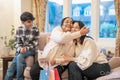 Happy senior woman embracing adult daughter during birthday visit in nursing home, grandson sitting next to grandmother