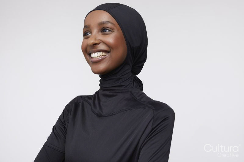 Studio shot of smiling young woman in hijab