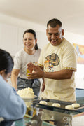 Members of family preparing food in kitchen