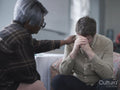 Therapist consoling patient in therapy session