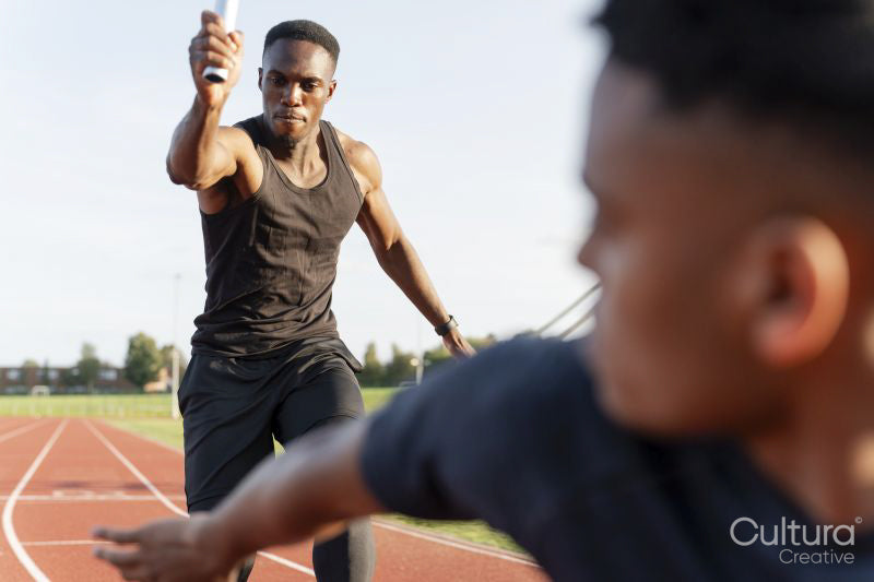 Two athletes running in relay race