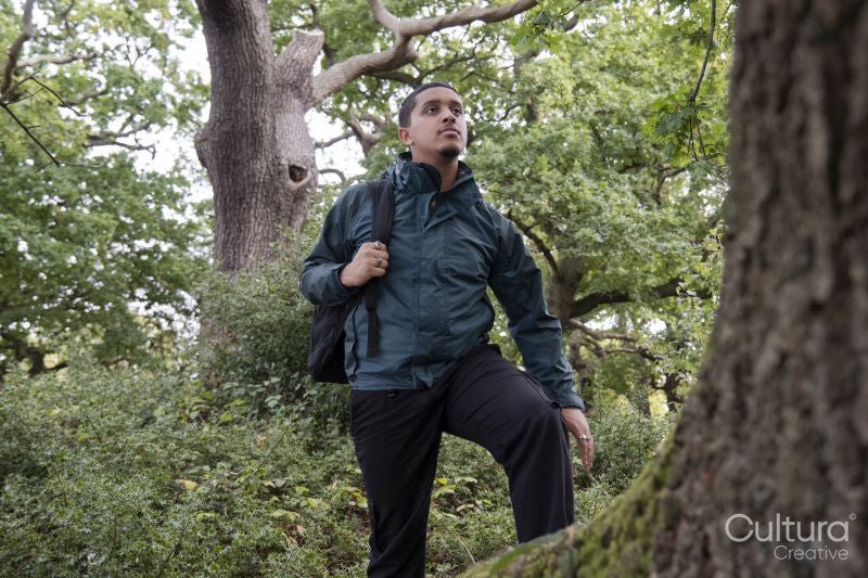 Man with backpack hiking in forest