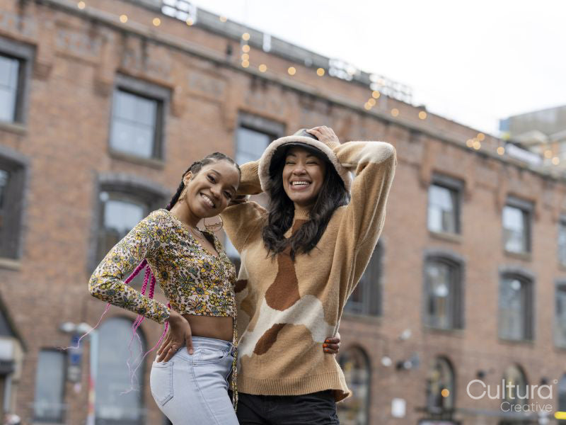 Two young women posing for portrait in urban setting