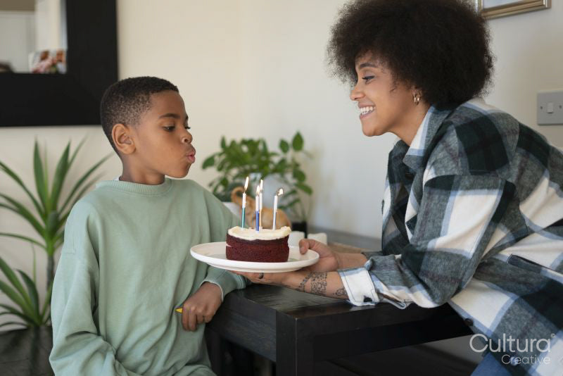 Boy blowing candles on birthday cake